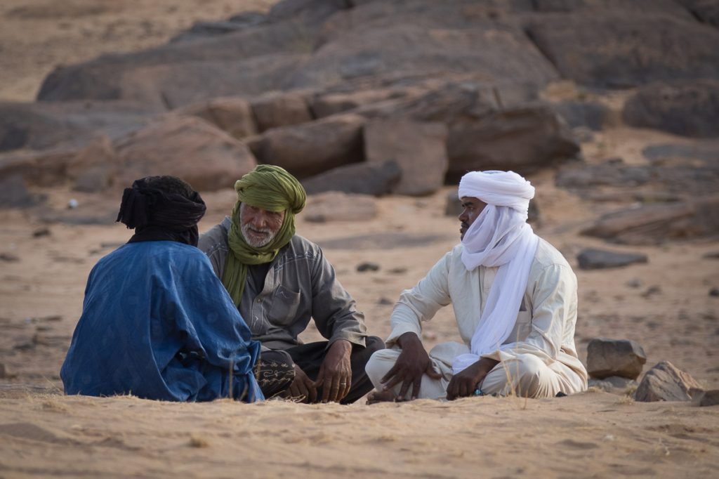 three sitting desert nomads